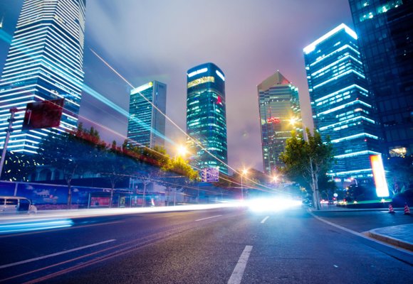 Flashing cars on the road between buildings