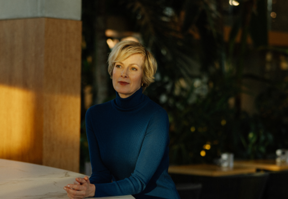 Building owner standing in her carbon-free sustainable hotel building, showcasing modern eco-friendly design.