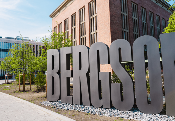 Black letters spelling BERGSON placed in front of a building, forming part of a stylish presentation that incorporates the building into the display.