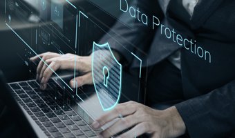 Person typing on laptop with holographic “Data Protection” shield, symbolizing Priva’s secure digital solutions.